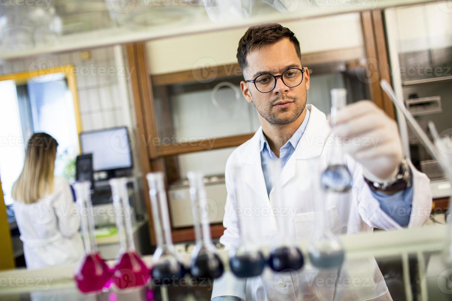 Young researcher checking test tubes photo