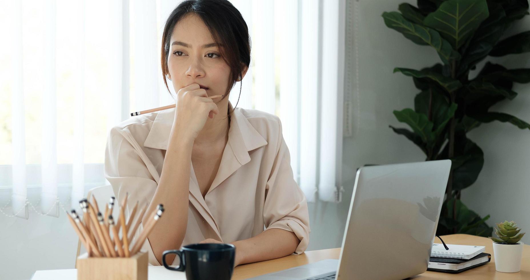 Woman thinking at desk photo