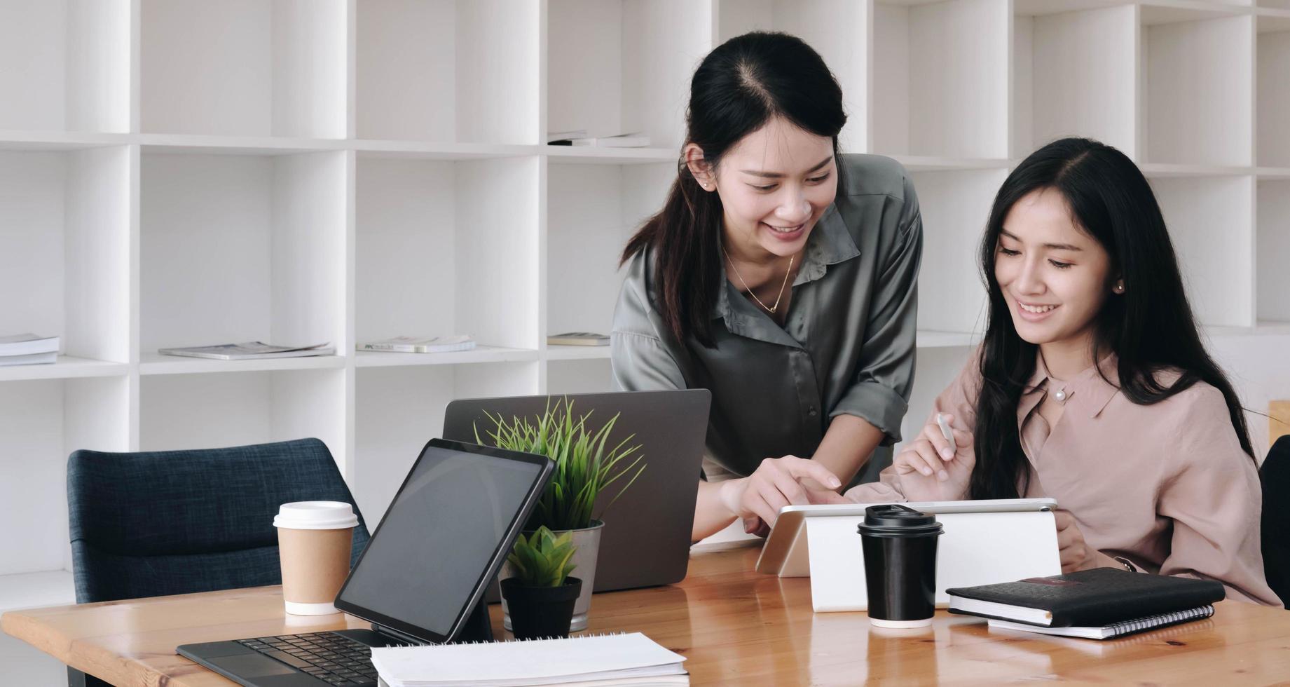 Two coworkers smiling while using a tablet photo