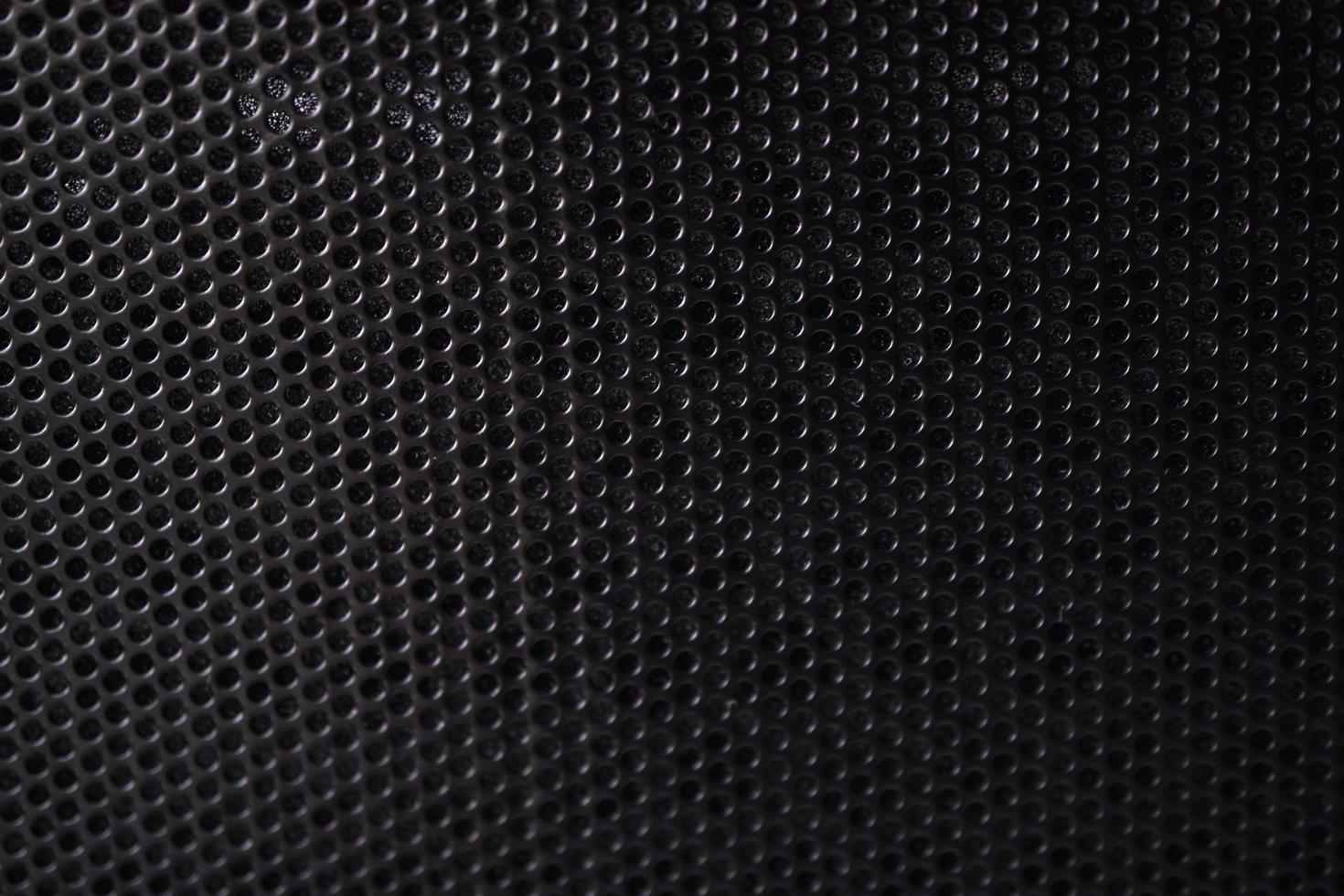 Black background made of iron grating with small round holes photo