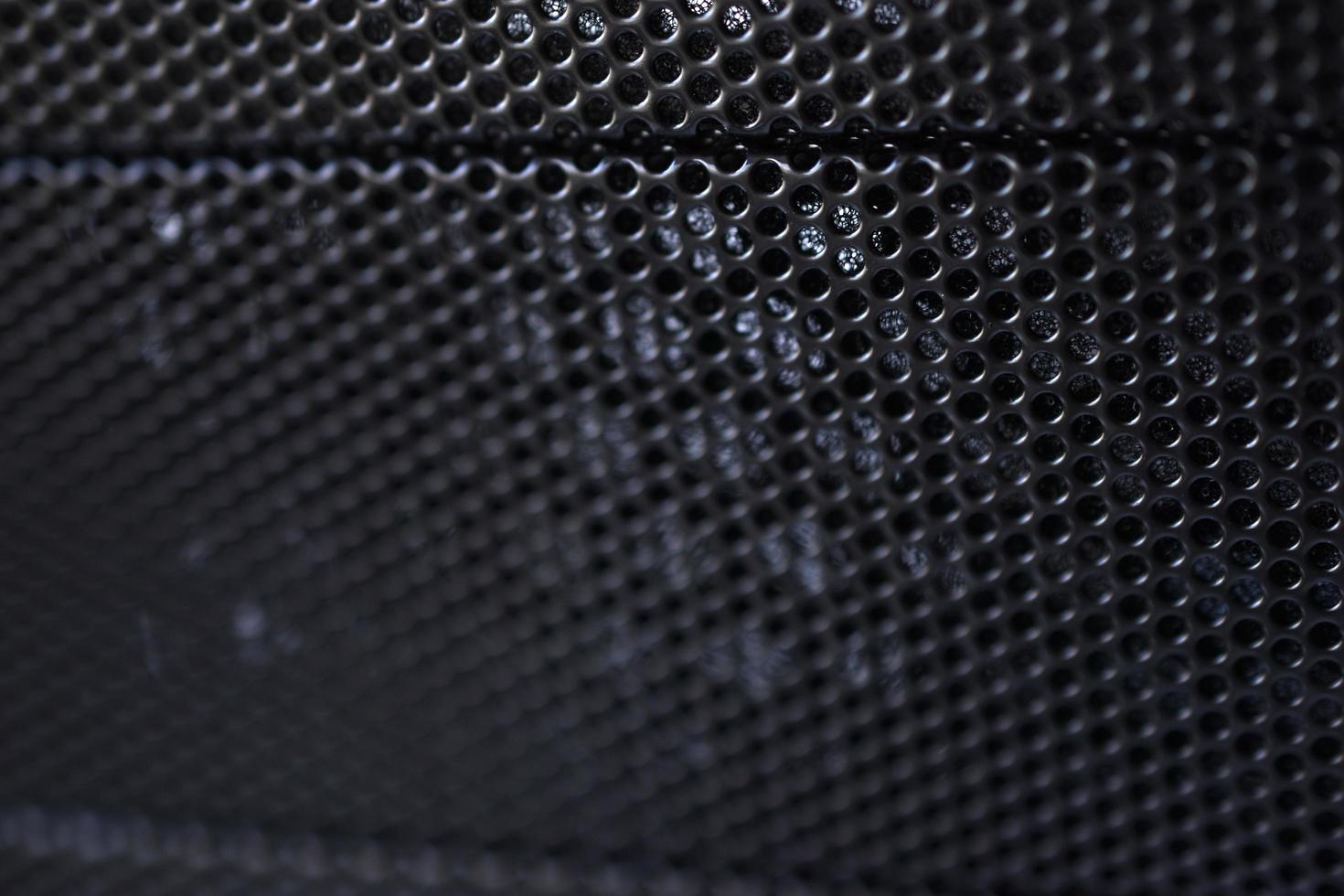 Black background made of iron grating with small round holes photo