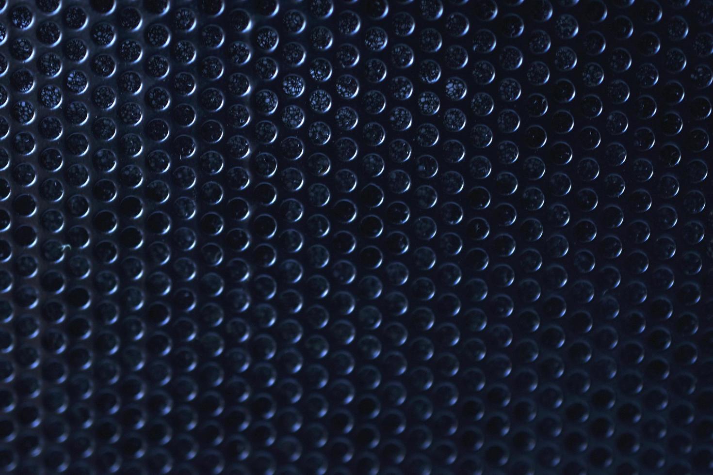 Black background made of iron grating with small round holes photo