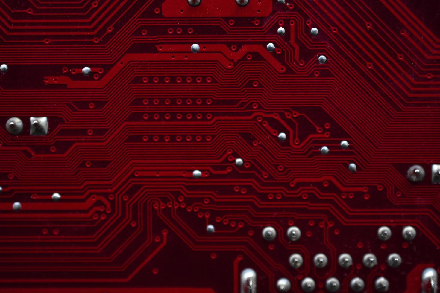 Red computer motherboard chips close-up with contacts photo