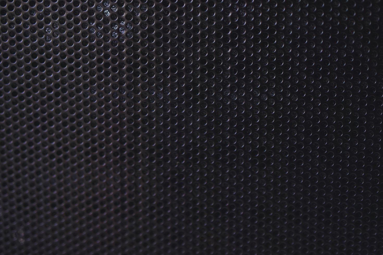 Black background made of iron grating with small round holes photo
