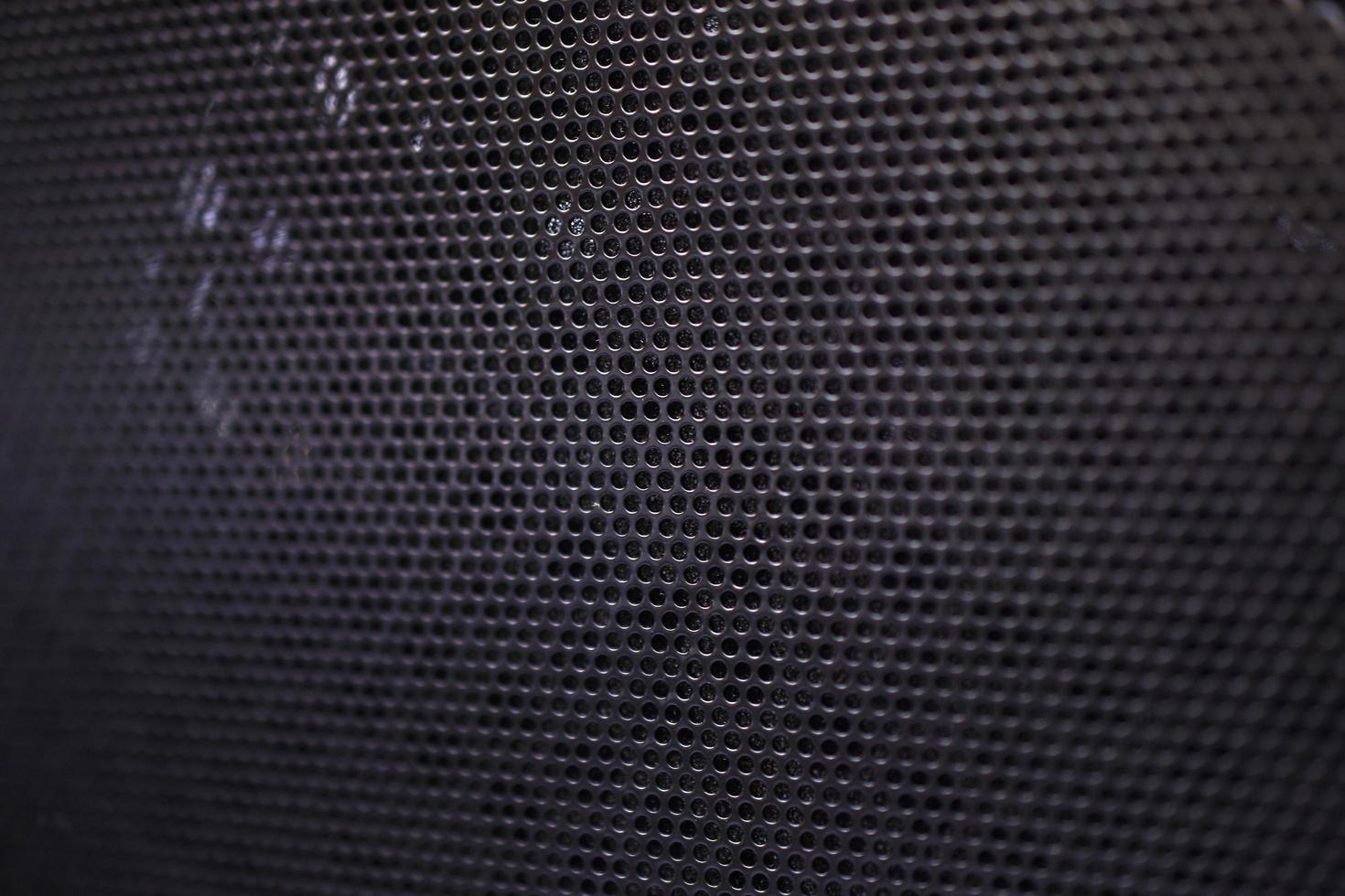 Black background made of iron grating with small round holes photo