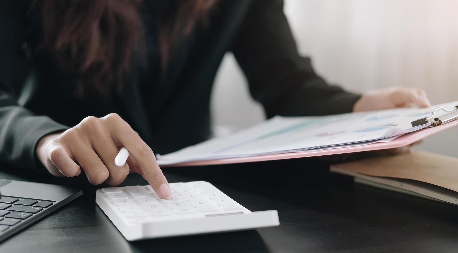 Close-up of a person using a clipboard and using a calculator photo