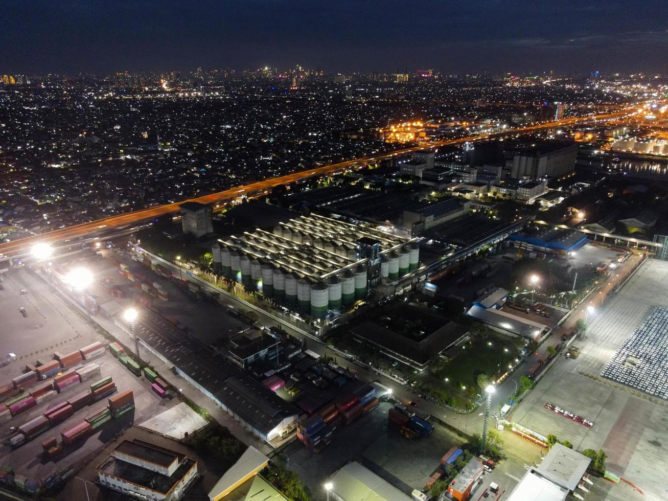 Yakarta, Indonesia 2021: vista aérea de la carga y descarga de un buque portacontenedores en el puerto de aguas profundas, transporte logístico de carga de importación y exportación en un buque portacontenedores en mar abierto por la noche foto