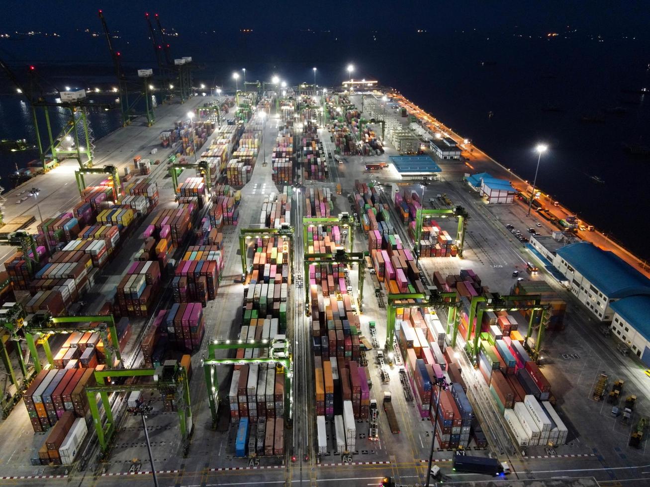 Jakarta, Indonesia 2021- Aerial view of Container ship loading and unloading in deep sea port, logistic import and export freight transportation by container ship in open sea at night photo