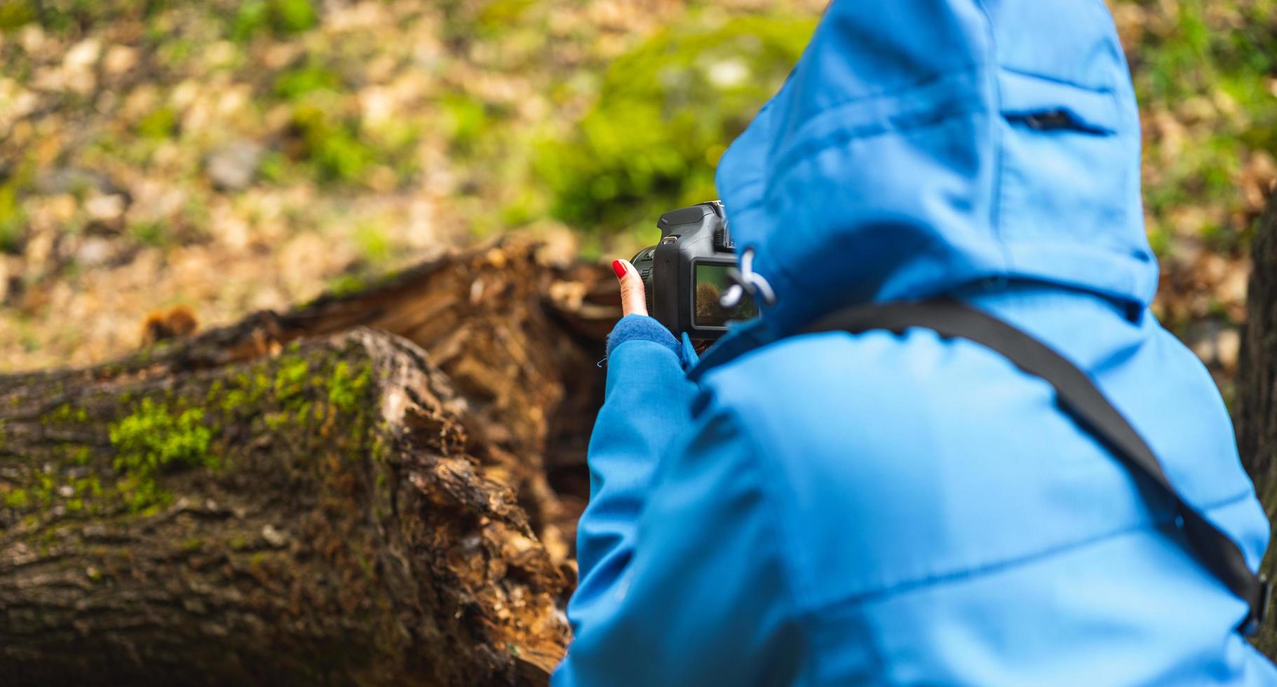 chica tomando fotografías con cámara réflex en la naturaleza foto