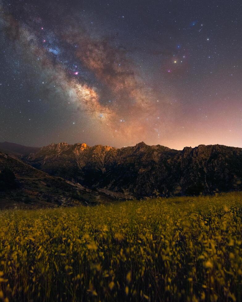 Panorámica de la colorida vía láctea sobre algunas montañas foto