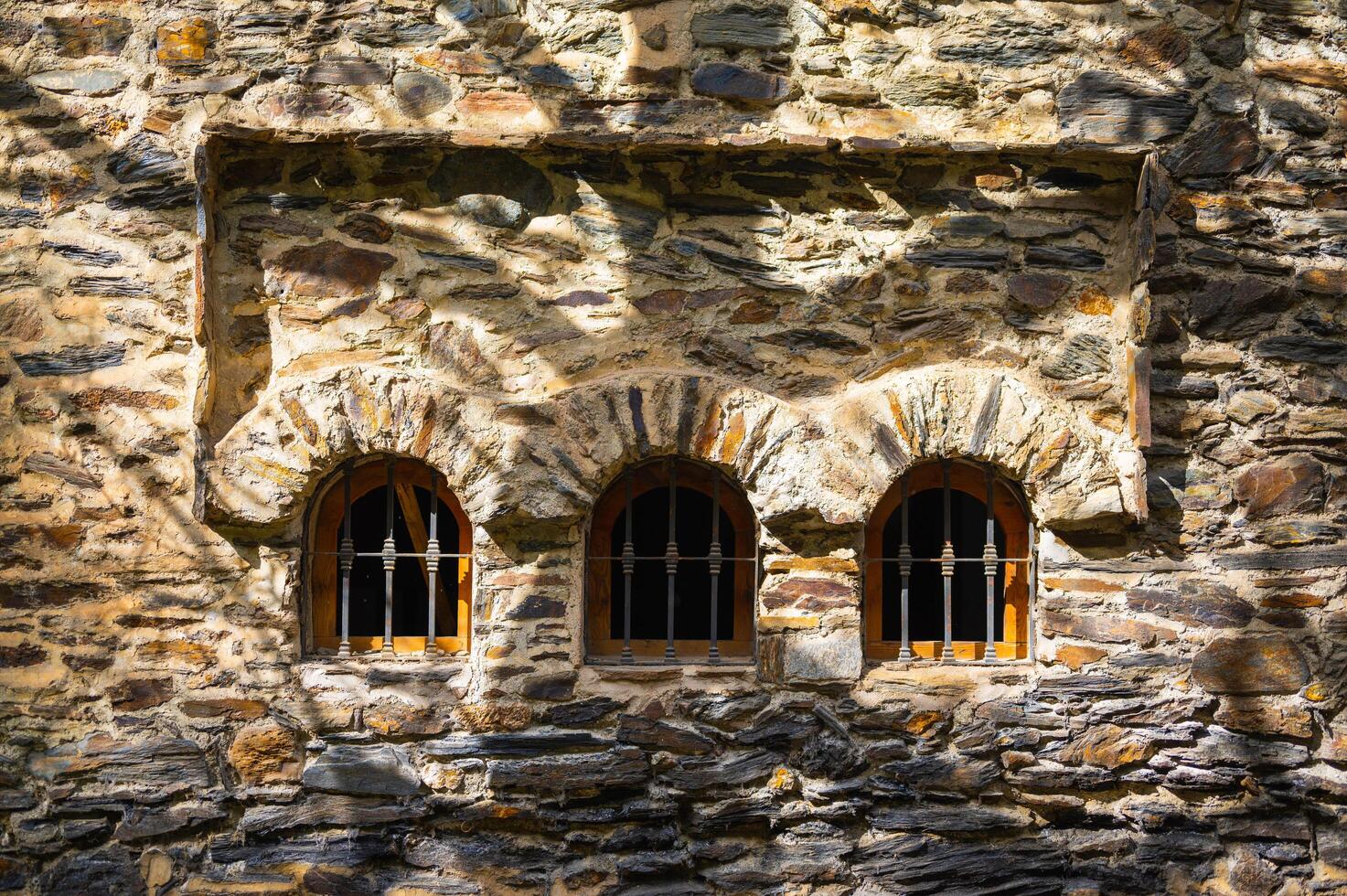 arcos de ventana de piedra con sombras de árboles foto