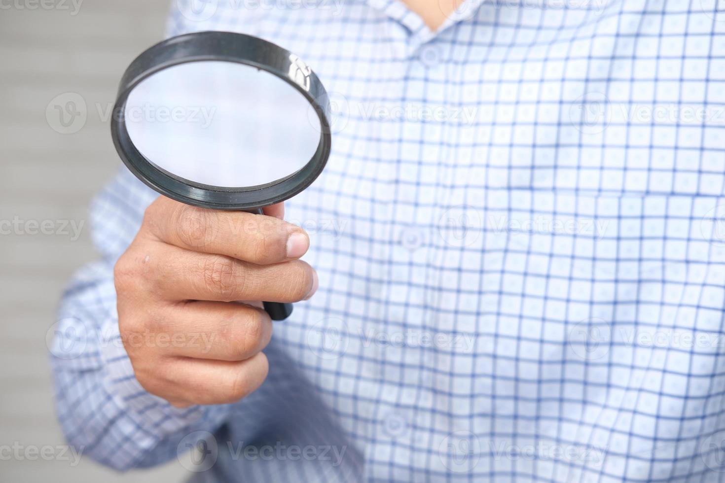 Man holding a magnifying glass photo