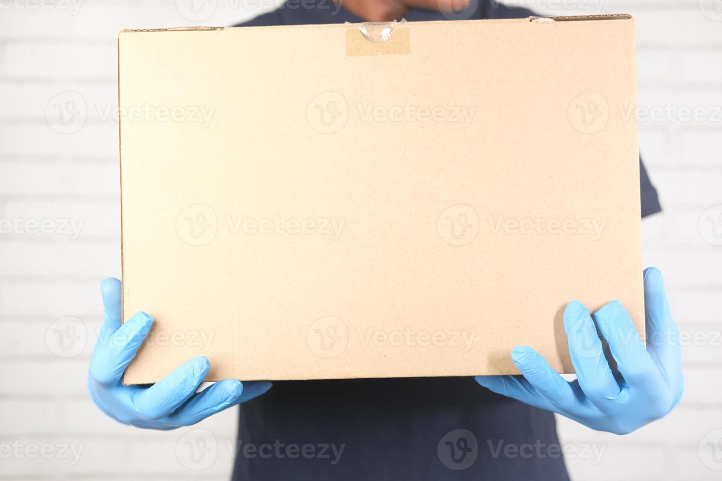 Person carrying a box with gloves on photo