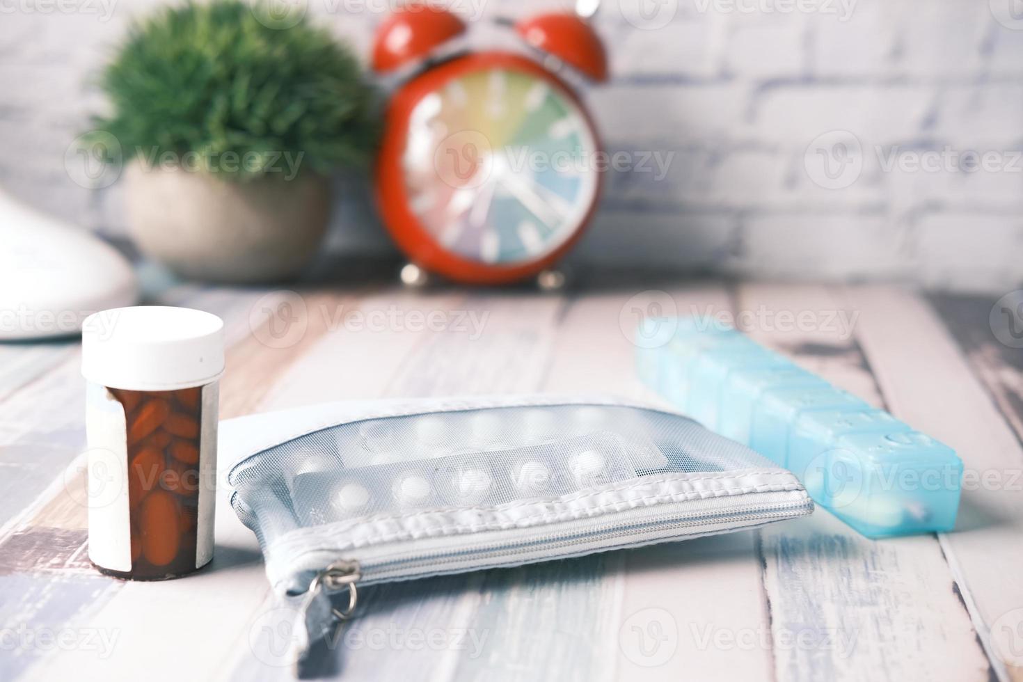 Medication with alarm clock in background photo