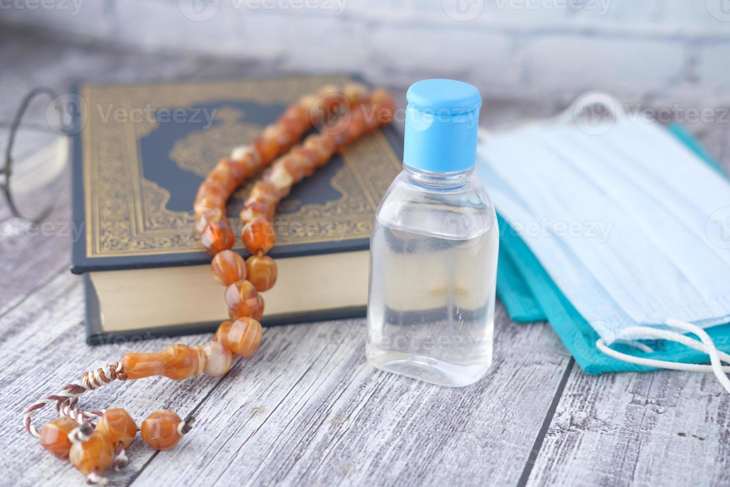 Quran with hand sanitizer and masks photo