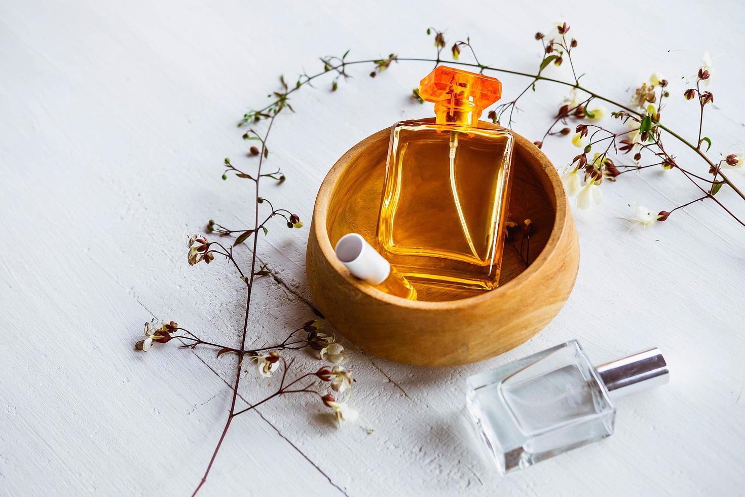 Three perfume bottles and a wooden bowl photo