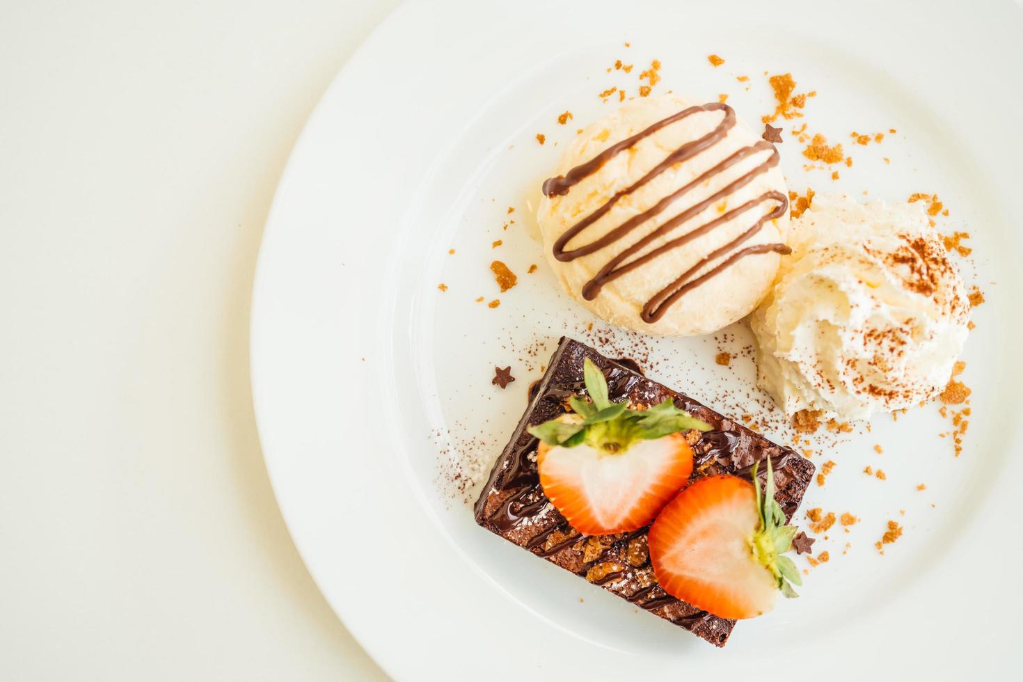 Vanilla ice cream with chocolate brownie cake with strawberry on top photo