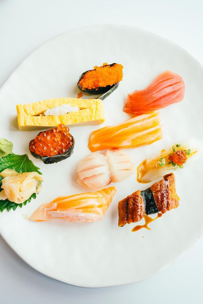 Sushi nigiri crudo y fresco en placa blanca. foto