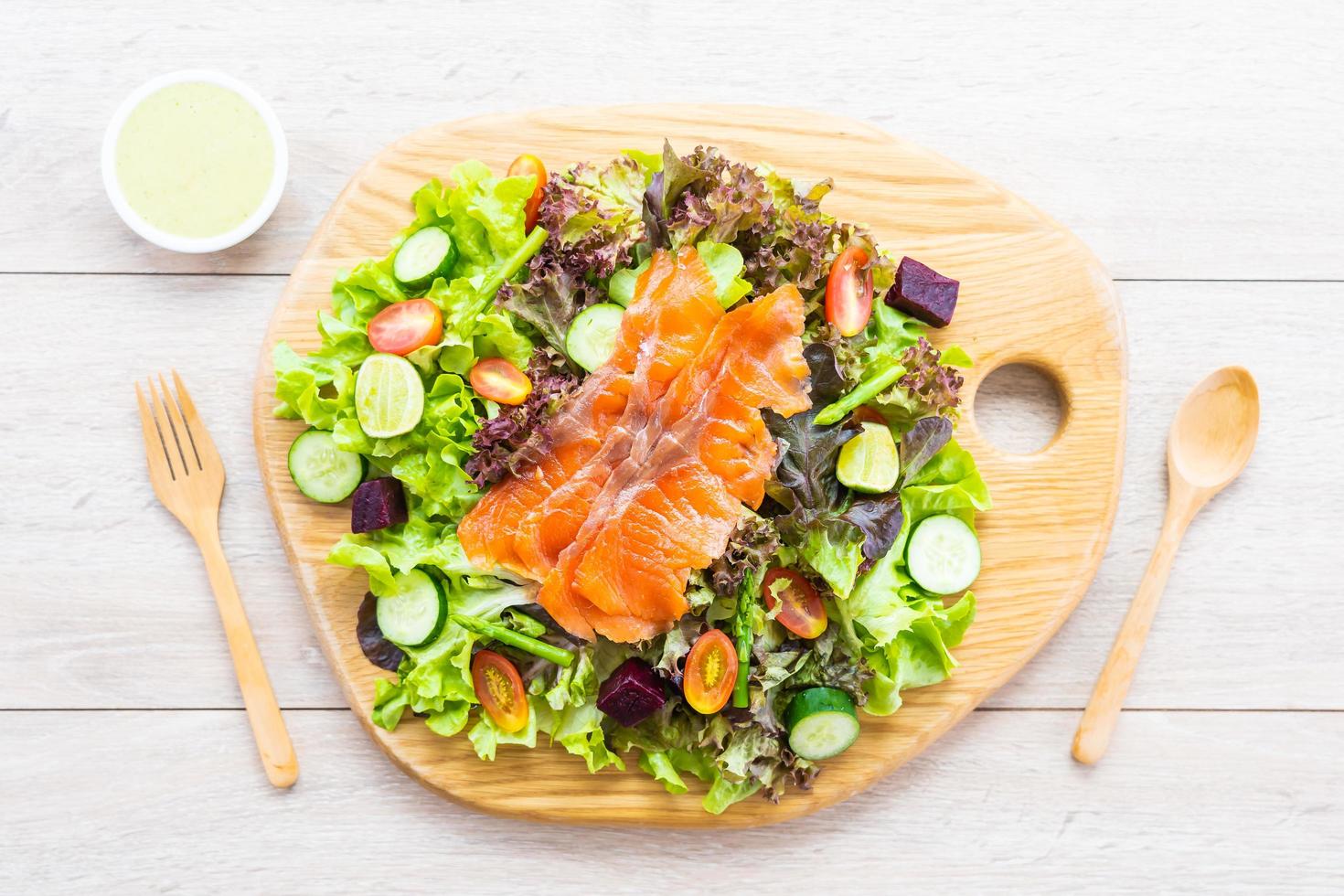 Raw Smoked salmon meat fish with fresh green vegetable salad photo