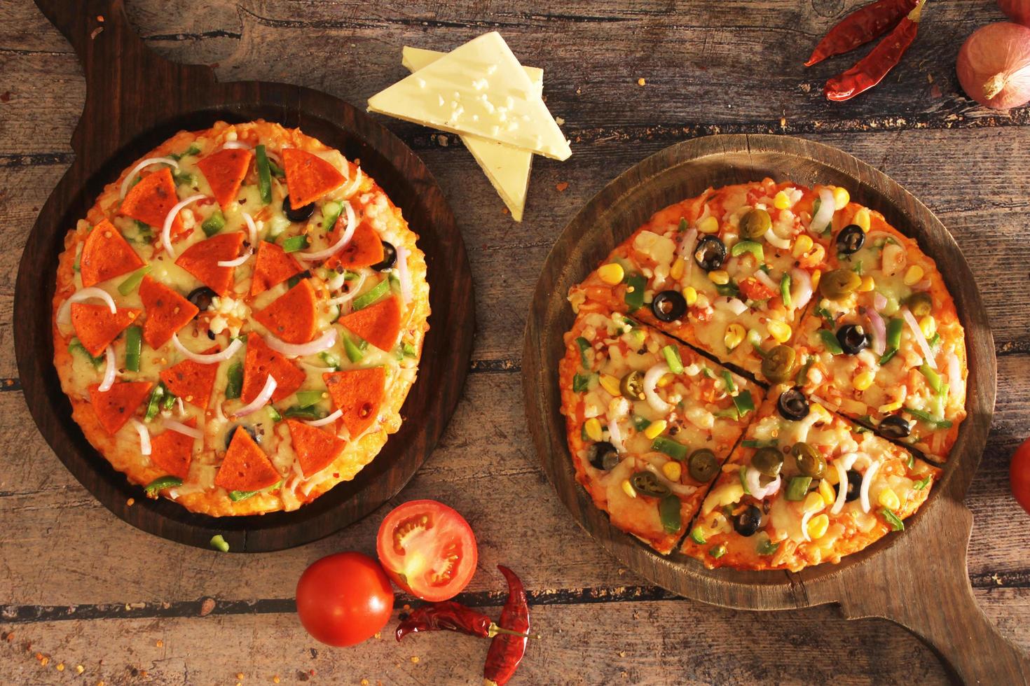Combo de pizza vegetariana y no vegetariana sobre fondo de madera foto