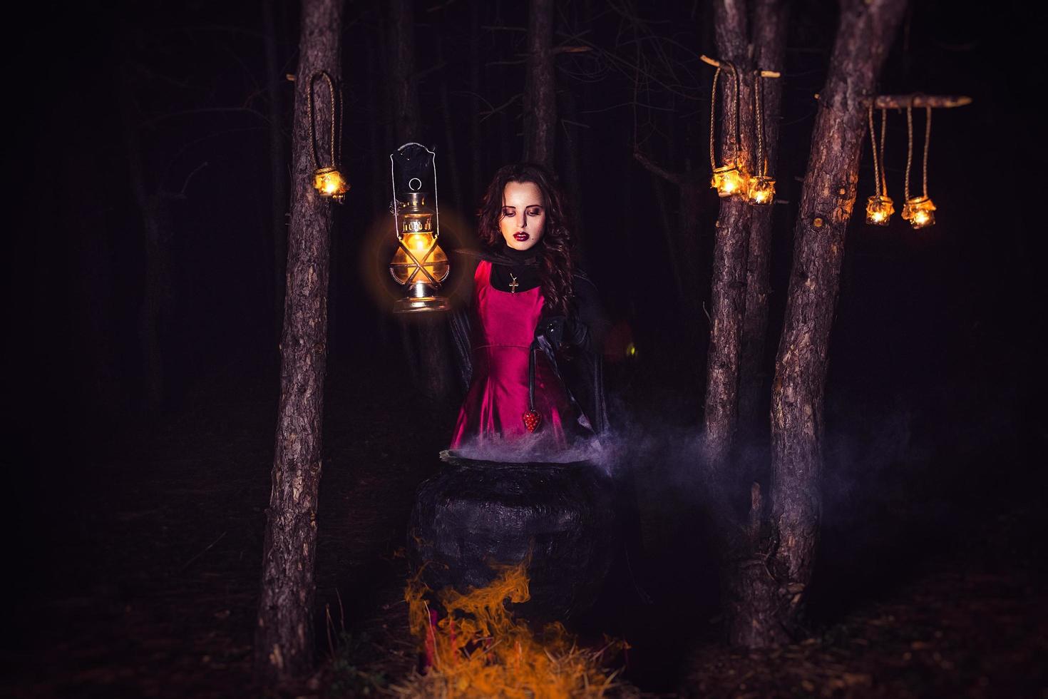 niña sola por la noche en el bosque prepara una poción y se maravilla para el matrimonio foto