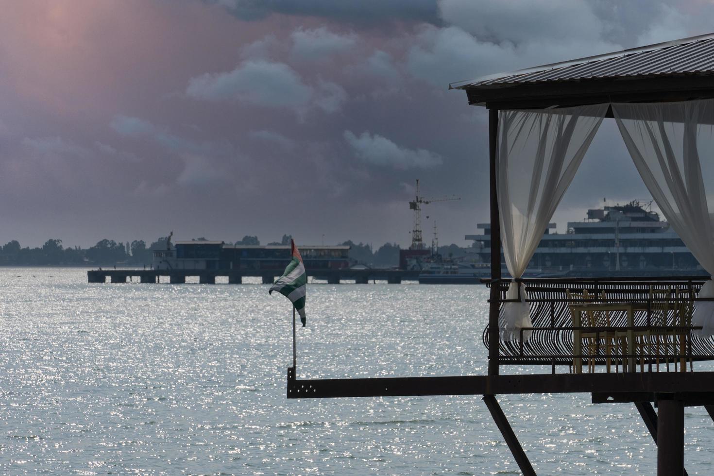 Seascape of a cafe by the sea and the Abkhazian flag in Sukhumi, Abkhazia photo