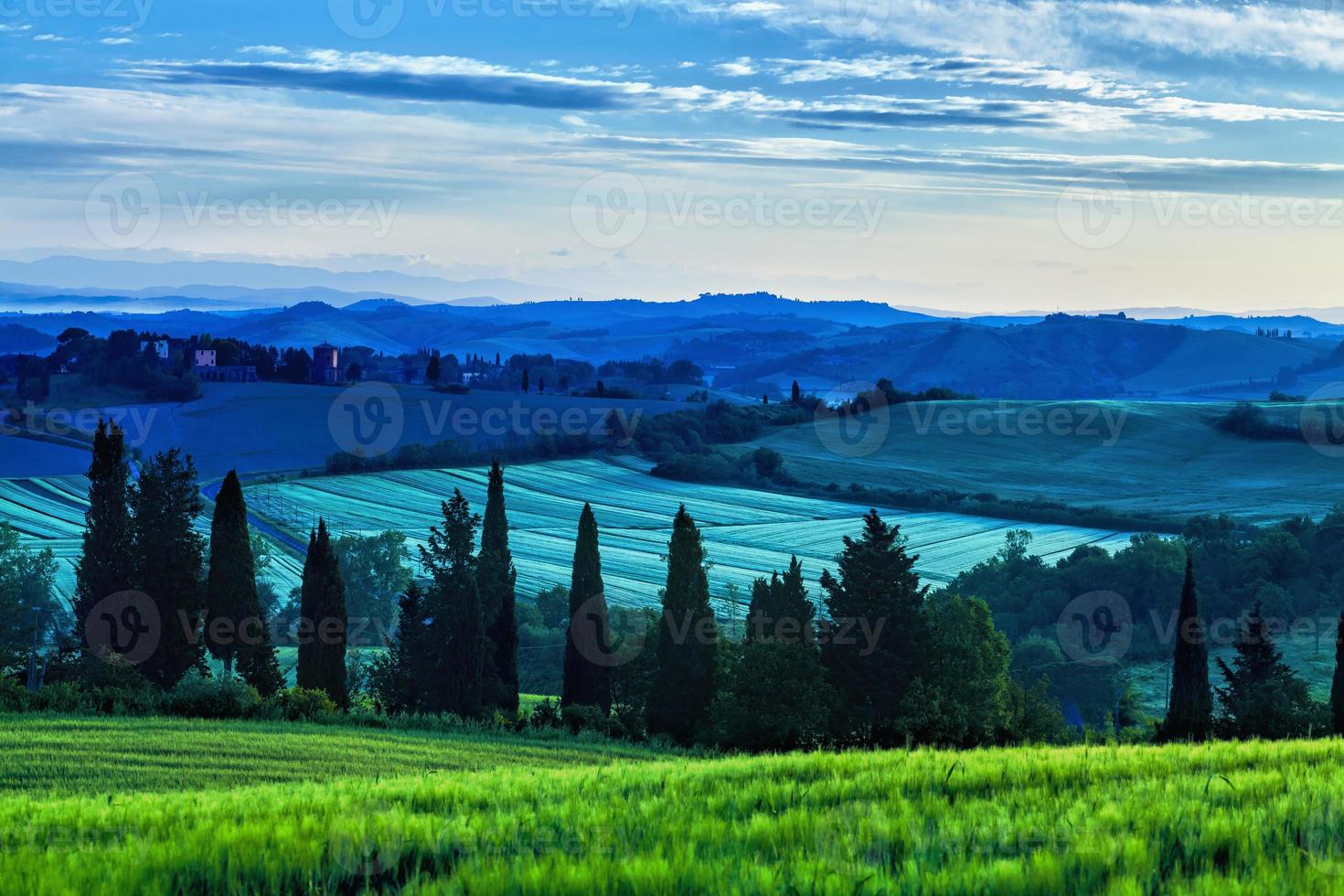 Amanecer sobre colinas con curvas en Toscana foto