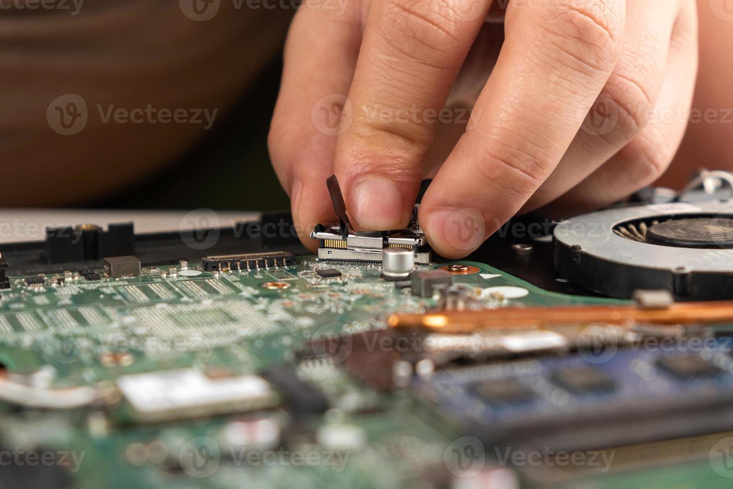 Close-up of a person repairing a laptop photo