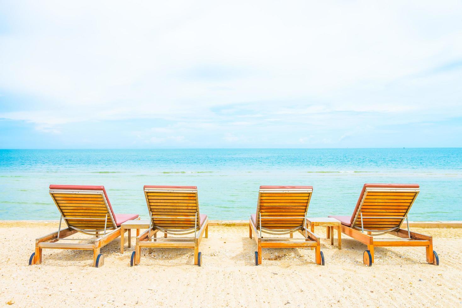 Camas para tomar el sol en una playa tropical foto