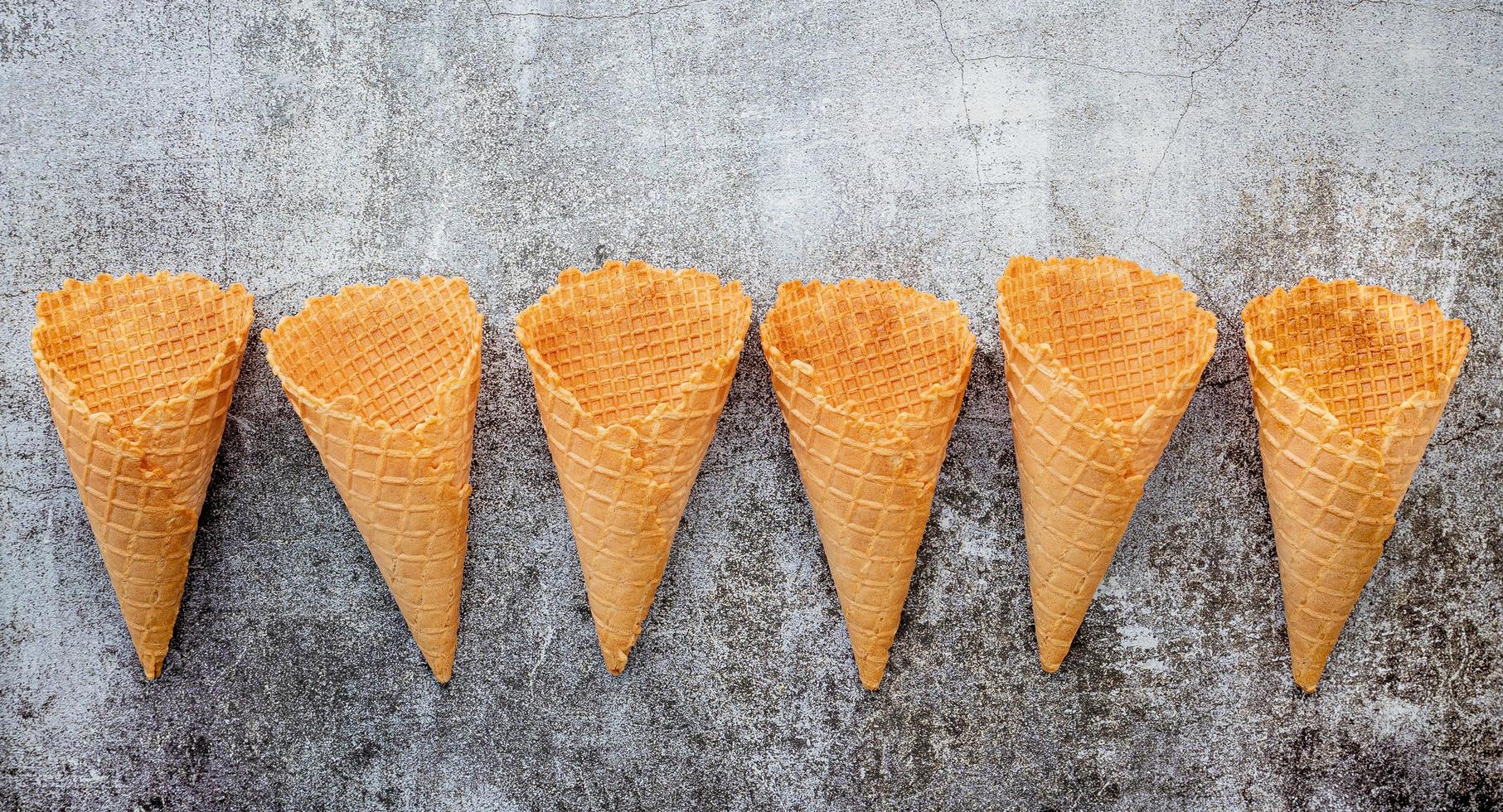 Flat lay ice cream cones collection on dark stone background photo