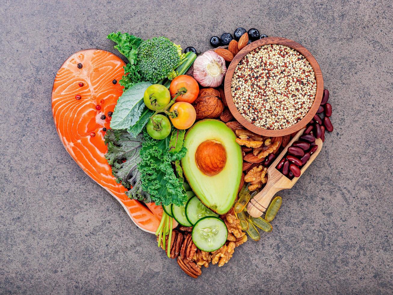 Ingredients for healthy foods selection on dark stone background in heart shape photo