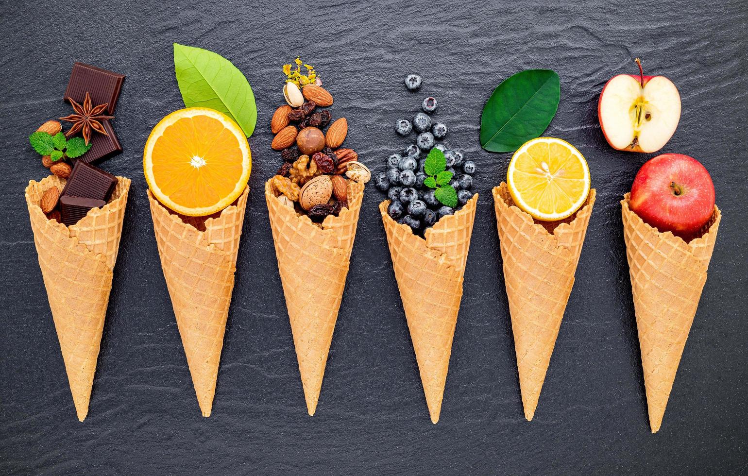 Various ingredients for ice cream flavors on dark stone background photo