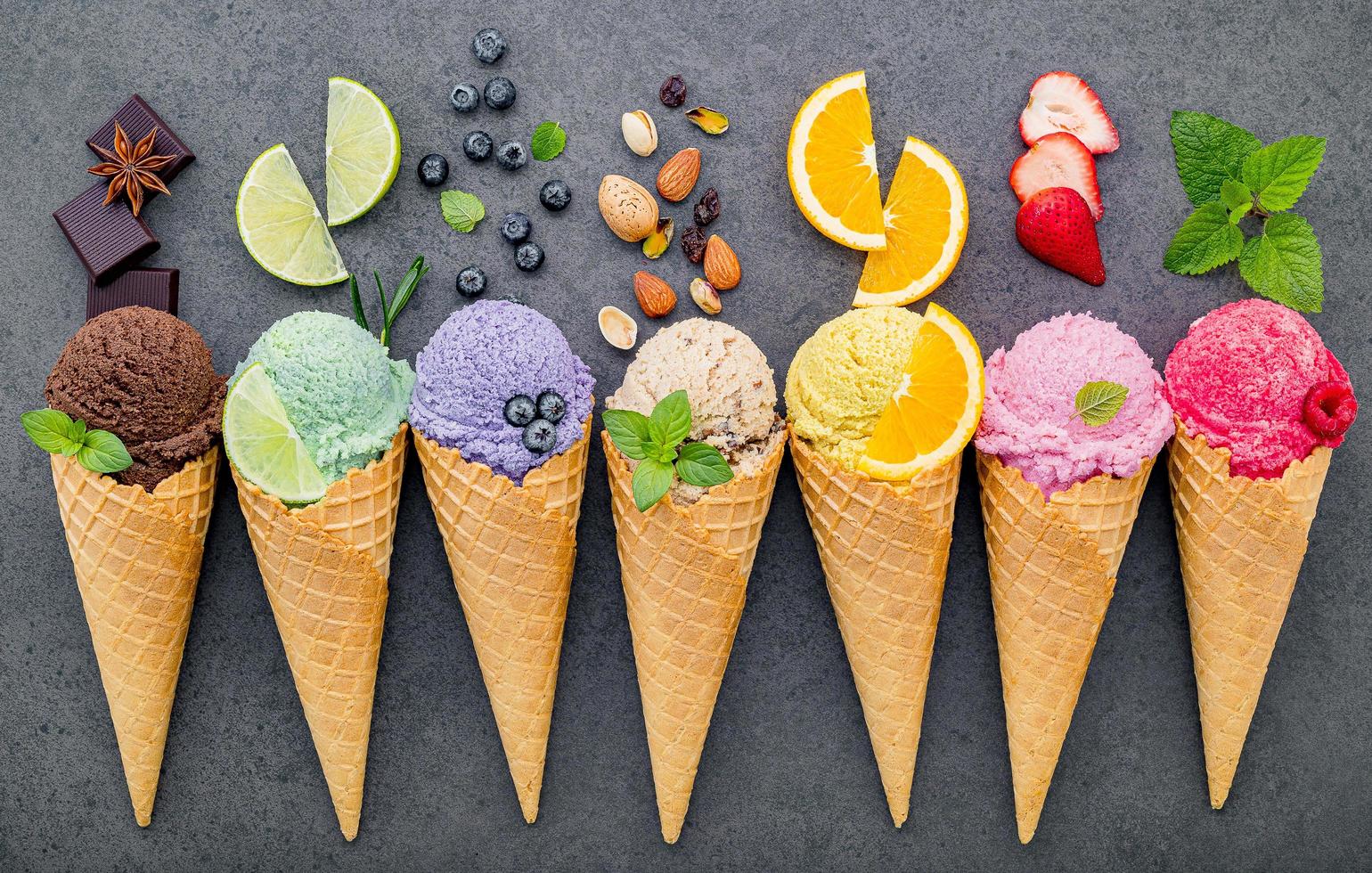 Colección de conos de helado planos laicos sobre fondo de piedra oscura foto