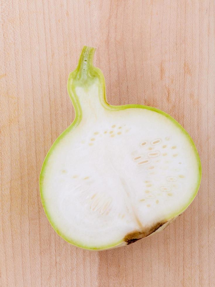 Calabaza de flores a la mitad sobre la superficie de madera foto