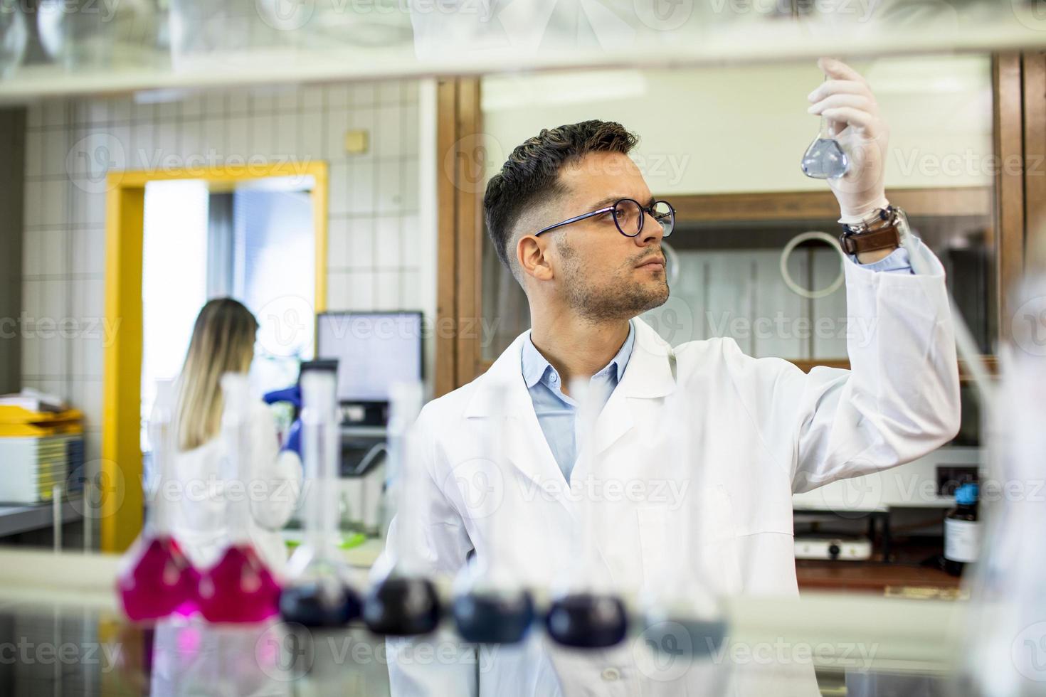 Young researcher checking test tubes photo