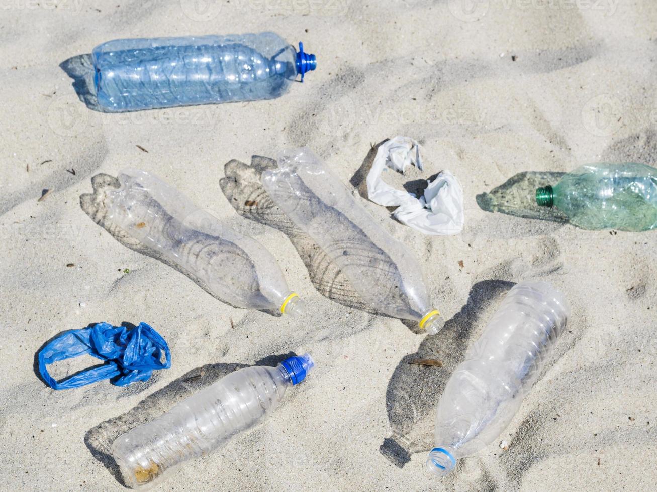 Botellas de agua de plástico vacías en la arena. foto
