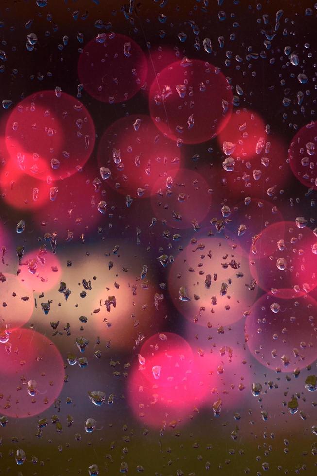 Raindrops and bokeh lights on the window photo