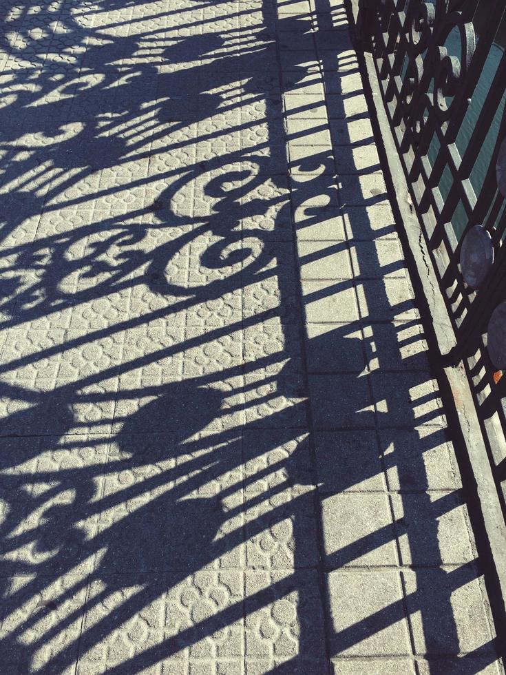 silueta de sombras de valla metálica en el suelo foto