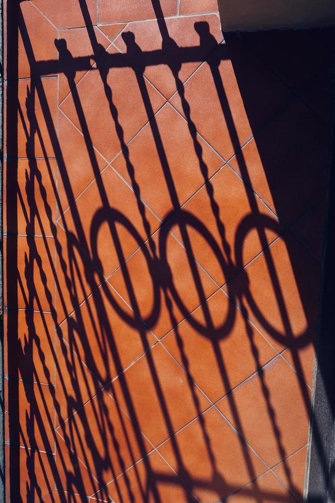 Metallic fence shadows silhouette on the ground photo