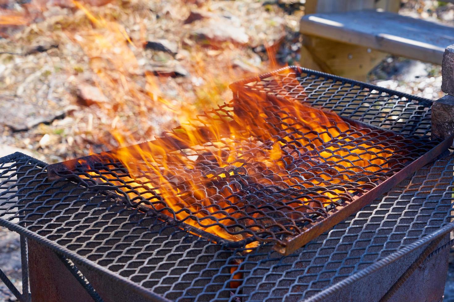 Fuego en una parrilla vintage oxidada al aire libre con fondo borroso foto