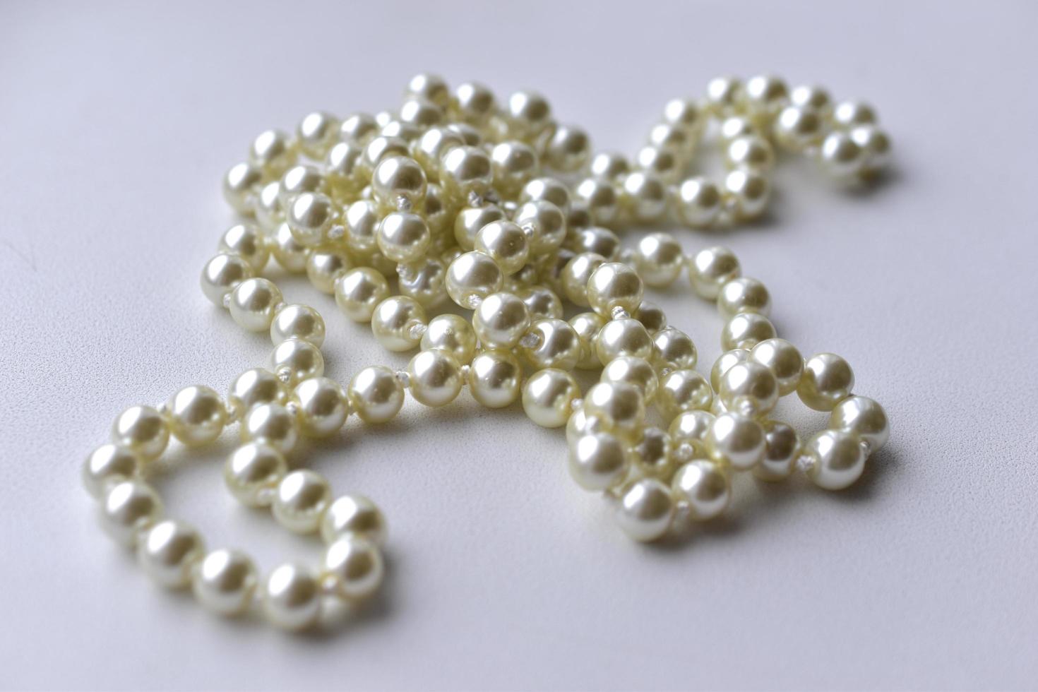 White pearl necklace beads on white background photo