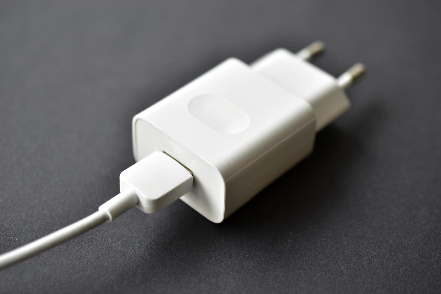 White mobile phone charger on black background photo