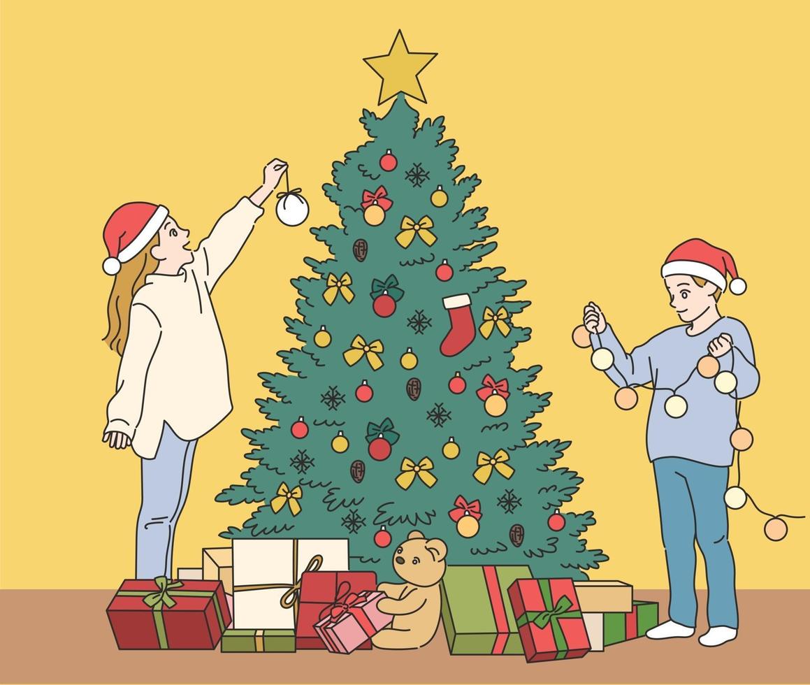 lindos niños están decorando el árbol de navidad. ilustraciones de diseño de vectores de estilo dibujado a mano.