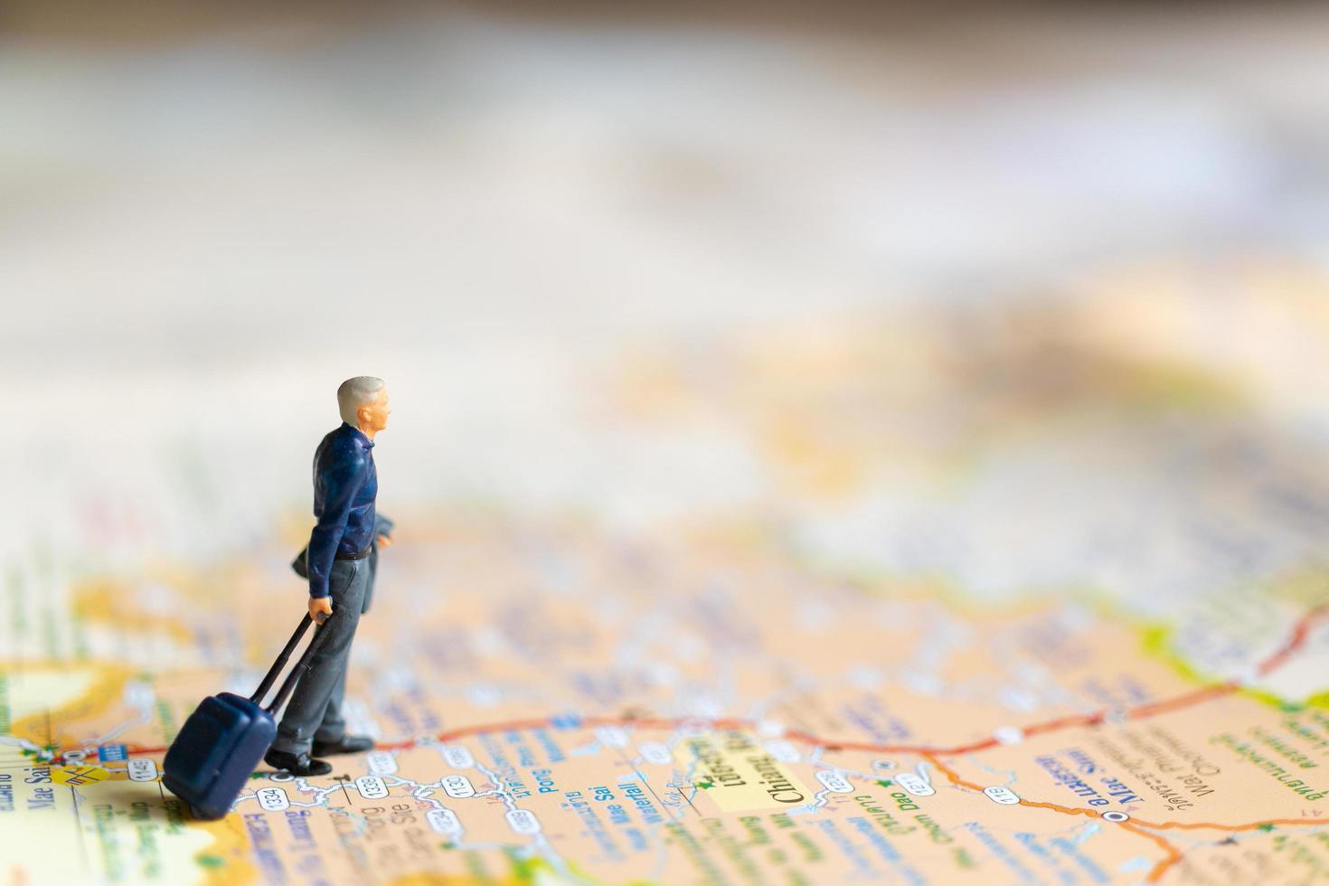 Empresario en miniatura de pie en el mapa, concepto de viaje foto