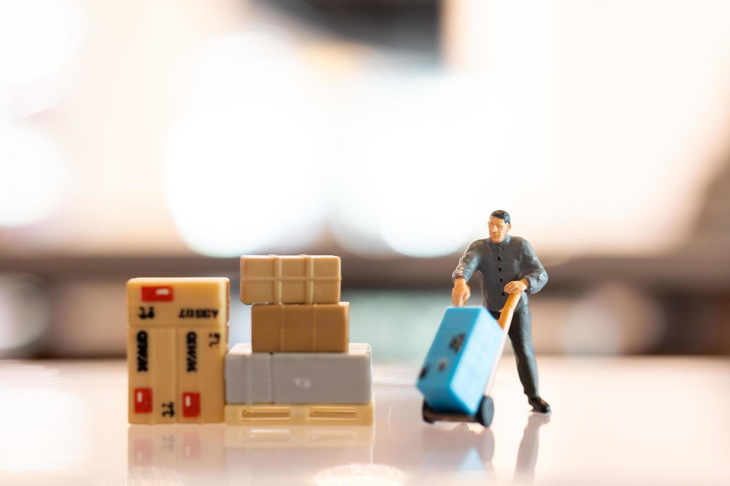 Miniature people, postman officers on duty preparing to send a box to the consumer. Delivery service for e-commerce concept photo