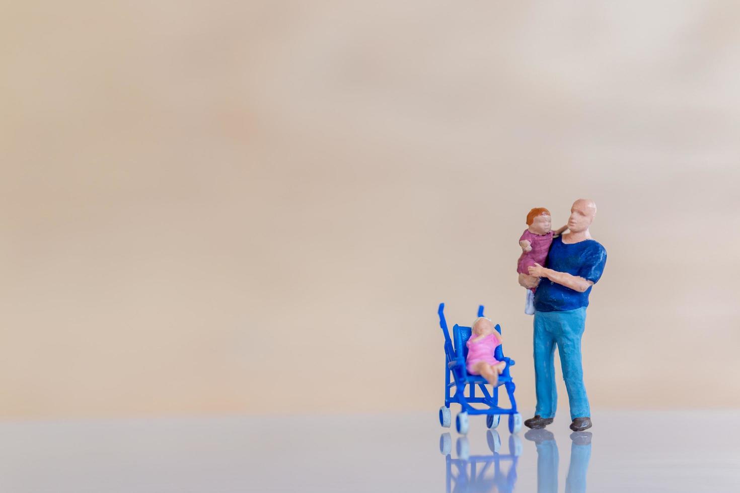 Miniature people, father holding their cute baby daughter in arms with copy space for text, Father's Day concept photo