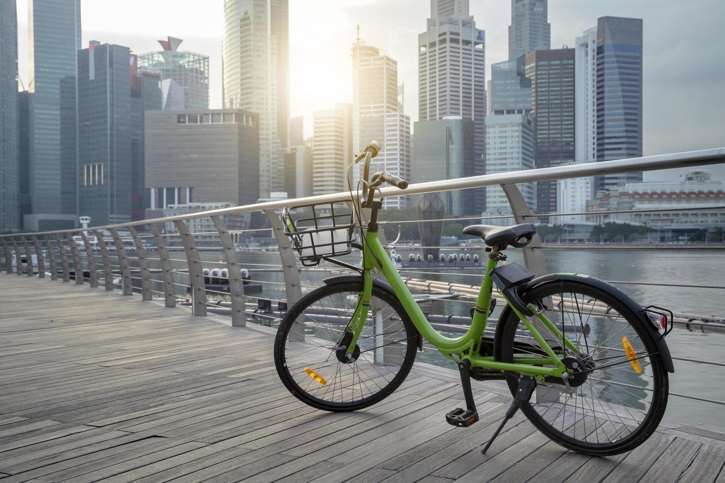 Bicicleta verde en el parque público y vista moderna Fondo del edificio comercial y vista del cielo Paisaje del edificio comercial en la ciudad central foto