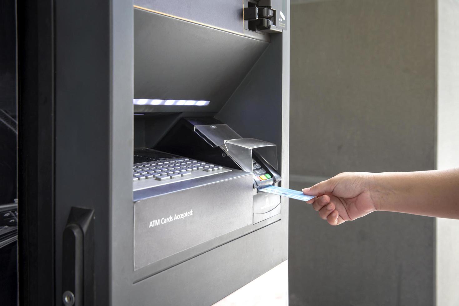 Close up of female hand using credit card at an ATM machine to withdraw money photo