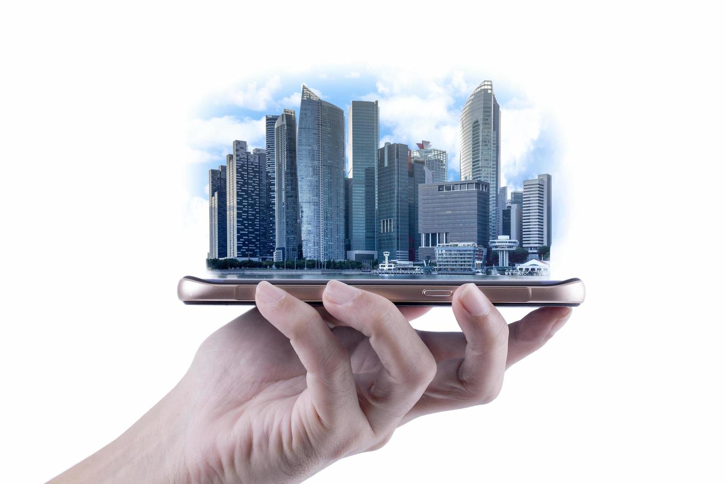 A man hand holding modern buildings of business financial district and commerce on smartphone, concept of industrial construction and success with technology photo