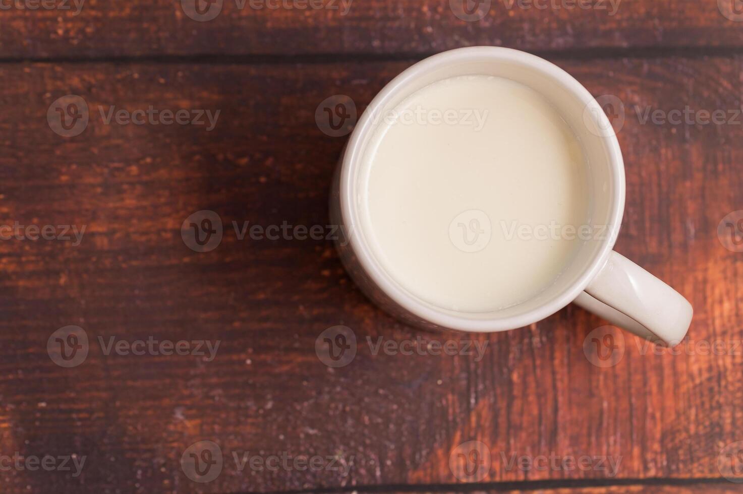 A cup of milk on a wooden table photo